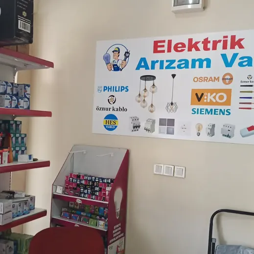 Dükkân içinde Elektrik Arızam Var marka panosu, ürün standı ve raflar